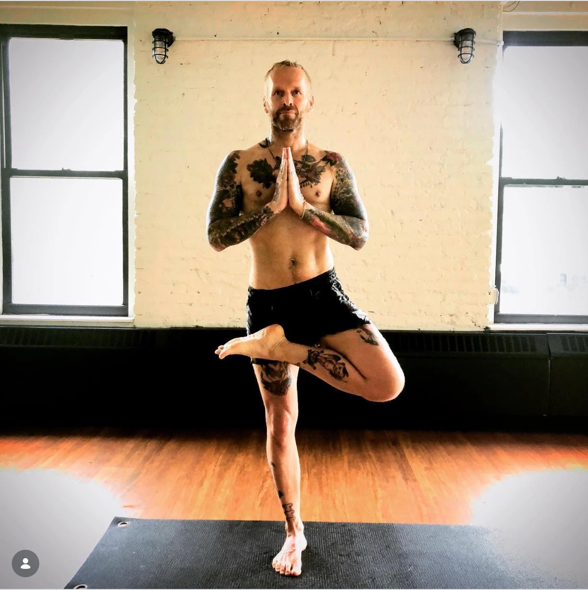 Bob Harper in a yoga tree pose in a bright studio